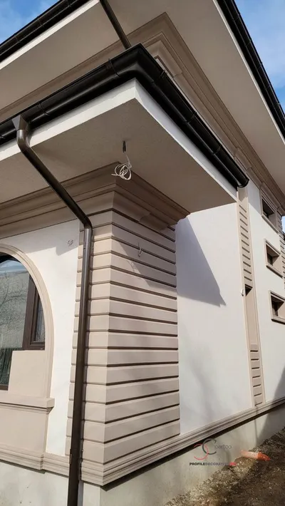 Ugao kuće sa horizontalnim fasadnim kockama, vencem ispod strehe i lučnim prozorom