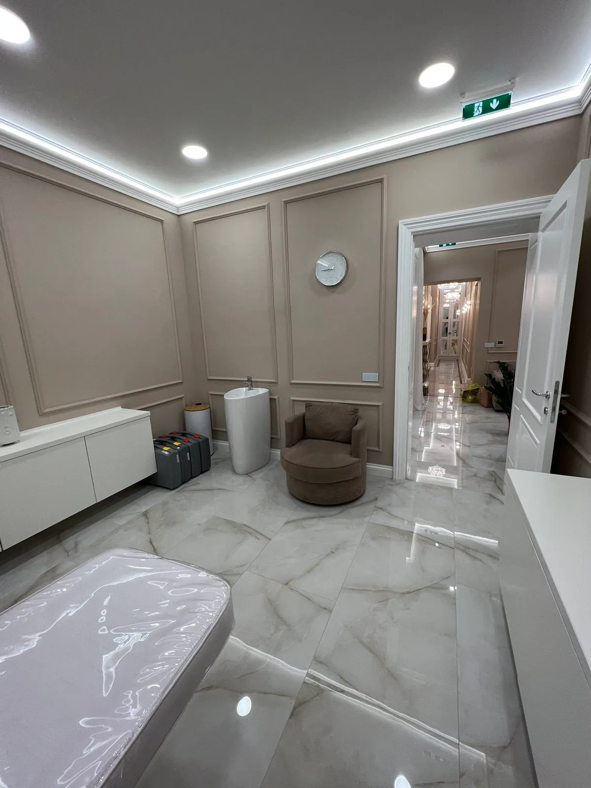 Salon lepote sa ram lajsnama, LED trakom i mermerom Prostorija salona sa ram lajsnama na zidovima, LED trakom oko plafona, mermernim podom i pogledom u hodnik
