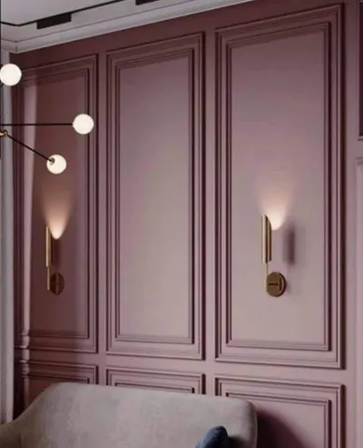 Zid u boji sleza sa ram lajsnama od poda do plafona, zlatnim zidnim lampama i modernim lusterom
